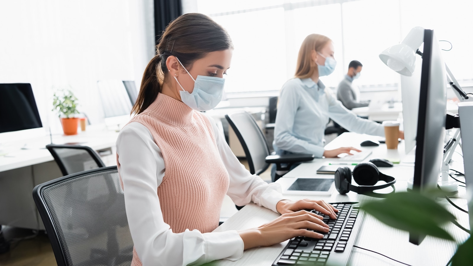 woman at desk with mask